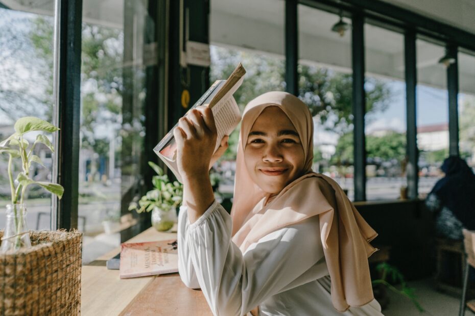 An Aceh (Acehnese/Acehian) girl in a coffee shop covered by a book
